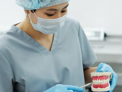 A doctor showing a TMJ patient a model of the mouth