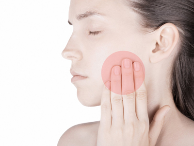 A woman with TMJ pain who is touching her face