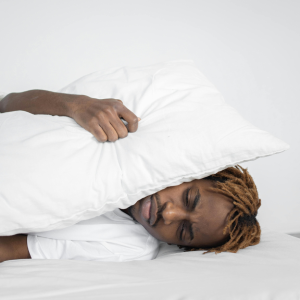 A man holding pillows over his ears