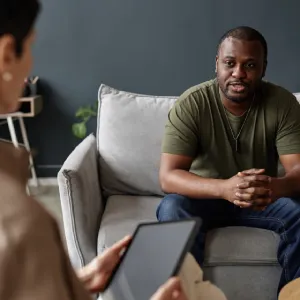 A young woman holding her hand to her pained eyes