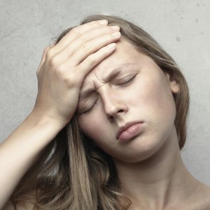 A woman touching the side of her face and ear