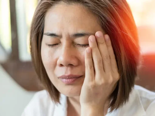 Woman holding the side of her jaw, where TMJ pain radiates